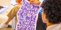 Student holding artwork in a classroom