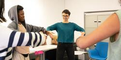 Students form a circle in a classroom. Photo by Kaylee Pugliese