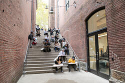 Studens drawing on steps between buildings