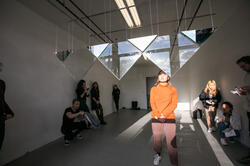 Student in front of an art piece participating in a critique session