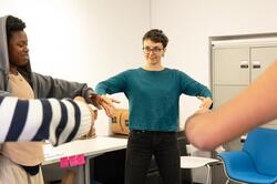 Students form a circle in a classroom. Photo by Kaylee Pugliese