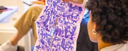Student holding artwork in a classroom