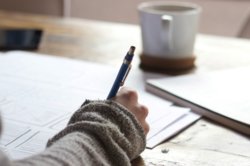 Image of a person taking notes on a notebook. Image credit: Unseen Studio / Unsplash