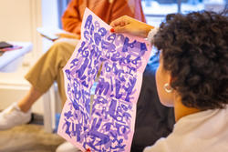 Student holding artwork in a classroom